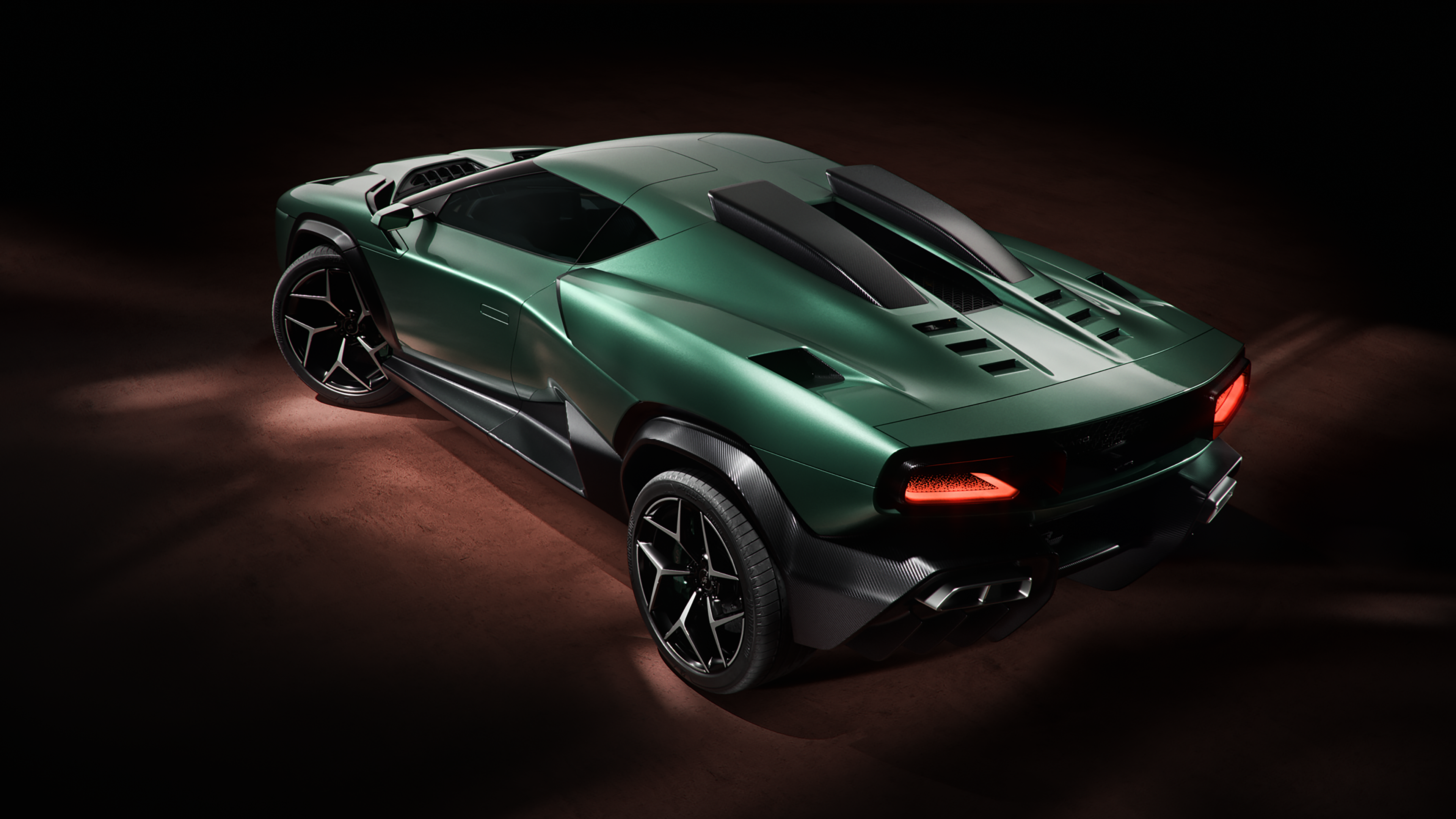 A rear three-quarter view of the green Giamaro Albor in a dark studio setting.
