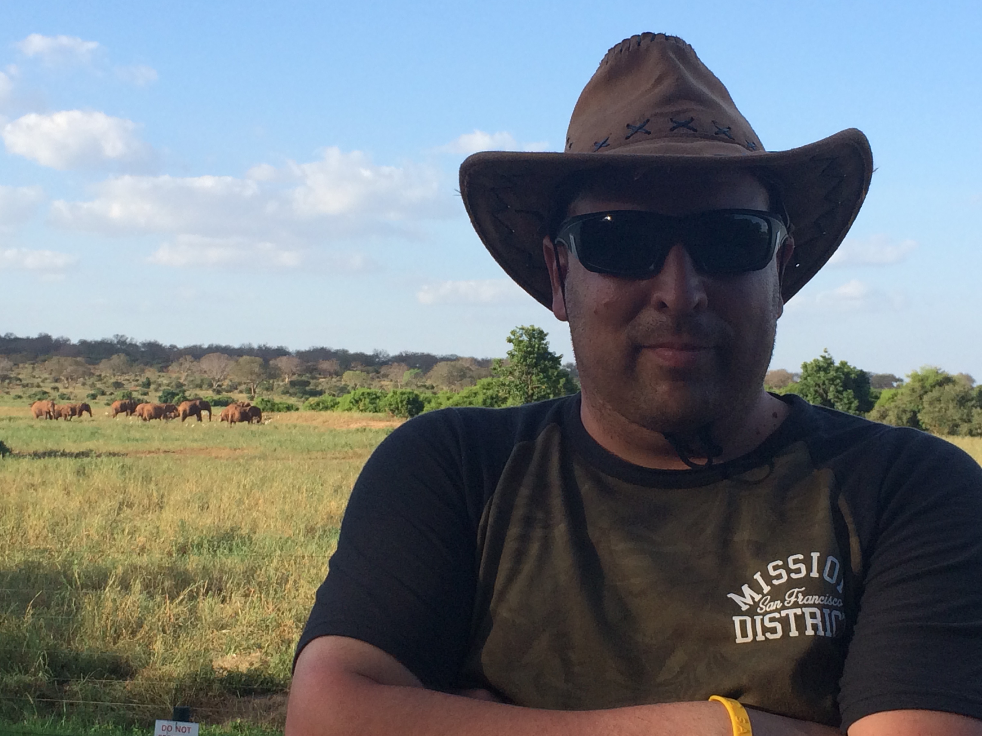 Man with elephants in the background in Tsavo East, Kenya